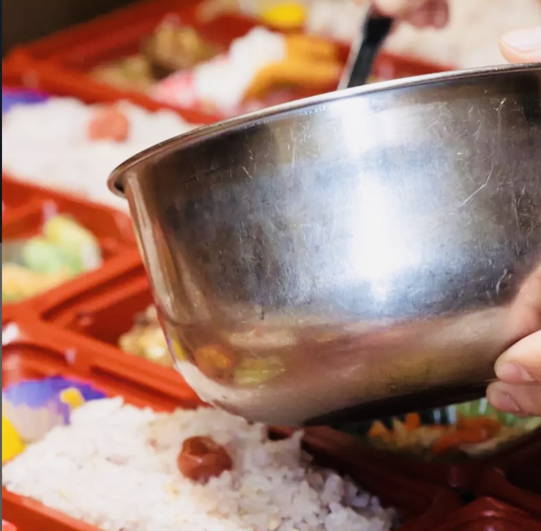お弁当におかずを盛り付ける手元